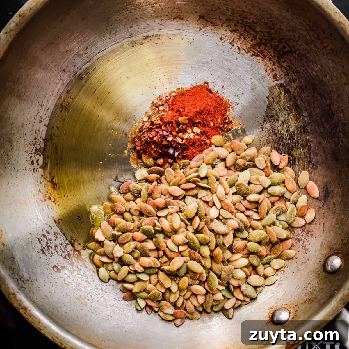 Maple-Roasted Carrots and Dates with Pistachio Pesto 9 Seed sprinkle ingredients in a frying pan before being cooked.