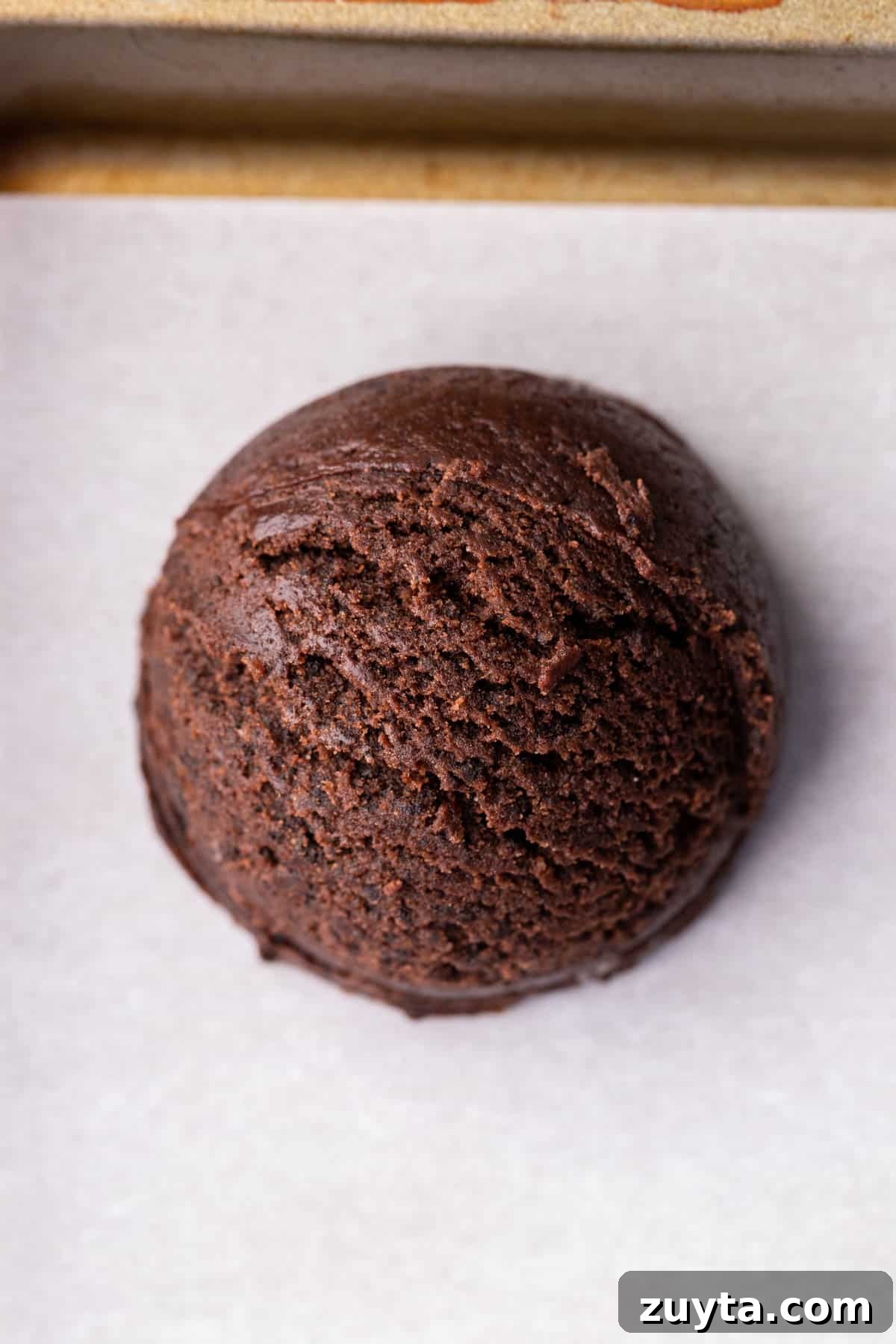 Cookie dough ball on a cookie sheet.