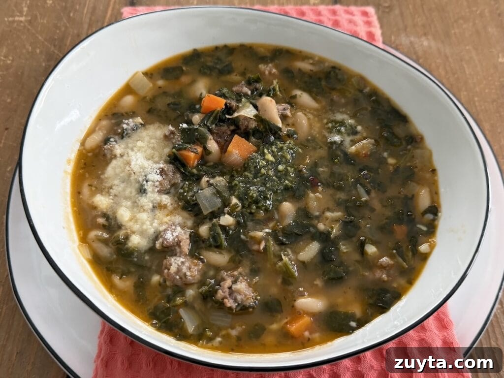 One-Pot White Bean and Sausage Soup 2 White Bean Sausage Soup in white soup bowl over decorative towel.