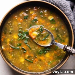 Vegetarian Sweet Corn Soup served in a black bowl with a spoon