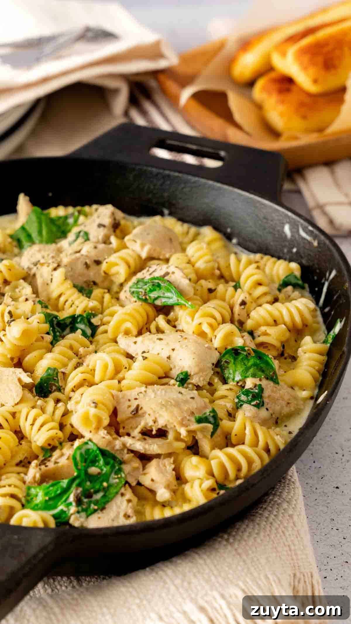 Instant Pot Creamy Pesto Chicken Pasta 2 Instant Pot Chicken Pesto Pasta served in a cast iron skillet with breadsticks.