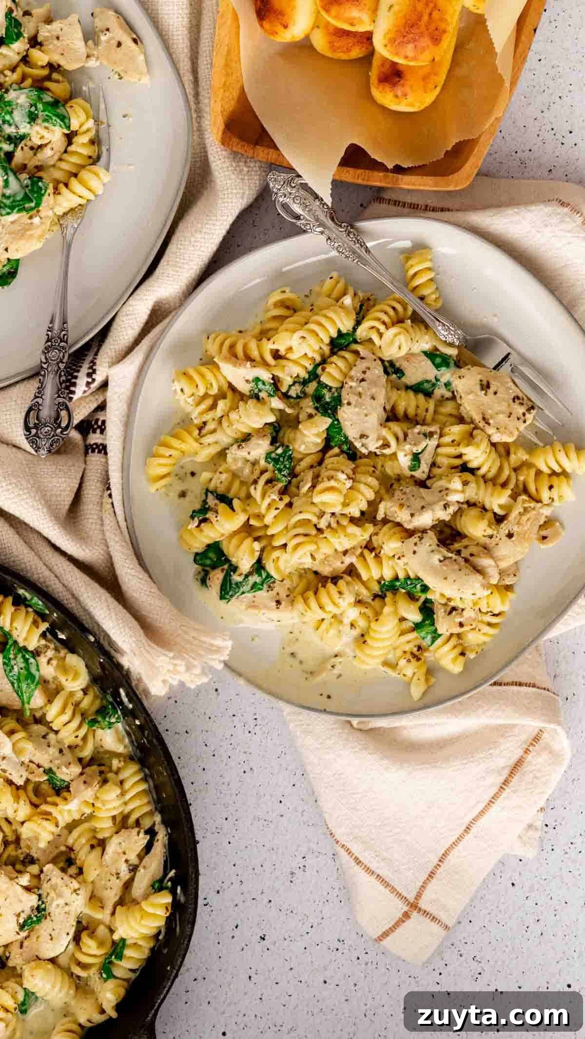 Instant Pot Creamy Pesto Chicken Pasta 5 Bird's eye view of Instant Pot Chicken Pesto Pasta on a plate tossed with spinach.