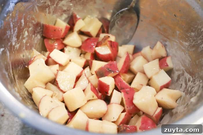 Slow Cooker Cheesy Ranch Potatoes Recipe 2 making Slow Cooker Cheesy Ranch Potatoes in a metal bowl