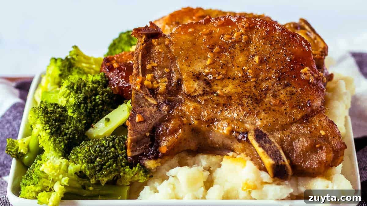 Foolproof Pork Chop Recipes for Juicy Weeknight Dinners 2 Pork chops on a plate with broccoli and mashed potatoes.