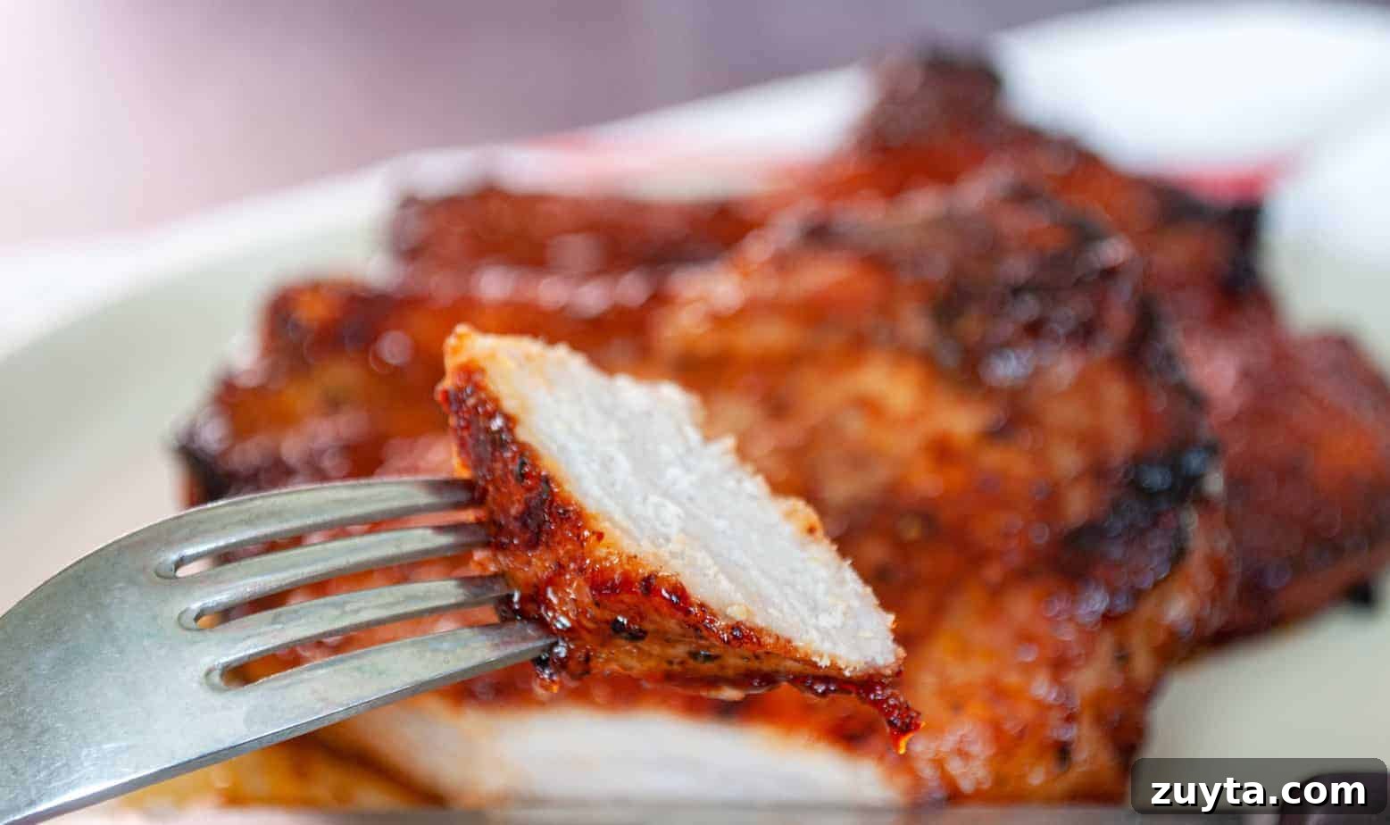 Foolproof Pork Chop Recipes for Juicy Weeknight Dinners 11 A bite of bbq pork chop on a fork.