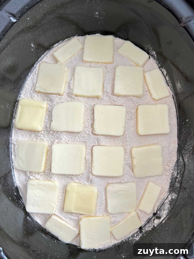 pats of butter on cake mix in crock pot