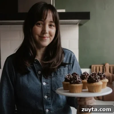 Double-Ginger Shortbread Cookies Recipe 16 Ella from Alpine Ella is holding a cake stand with cupcakes on it.