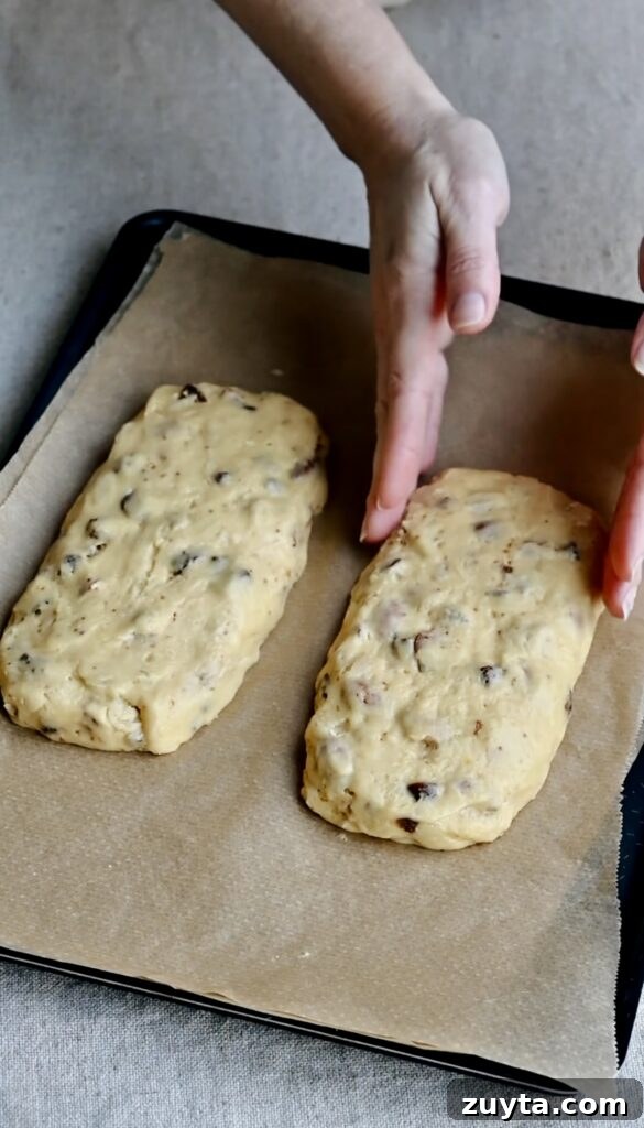Crisp Fig and Almond Biscotti Recipe 7 Two logs of biscotti dough on a parchment paper lined tray.