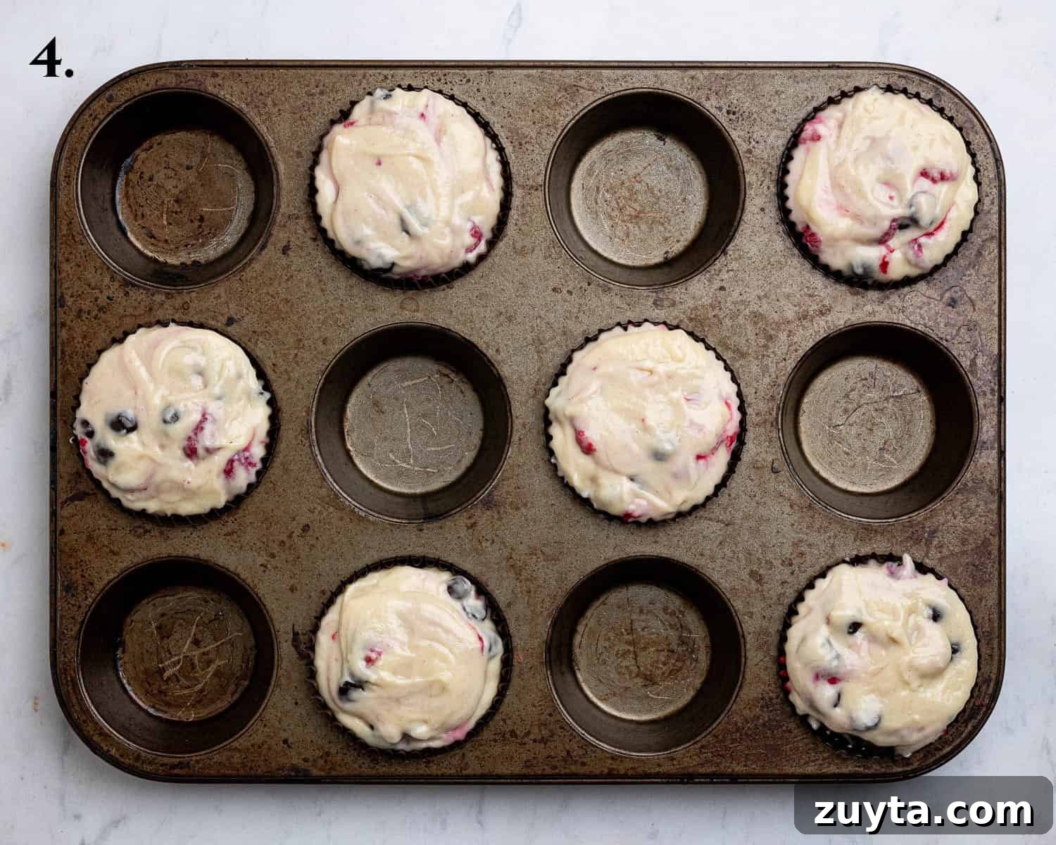 Vegan Chocolate Chip Raspberry Muffins Recipe 7 Step 4, the batter divided between the muffin cases.