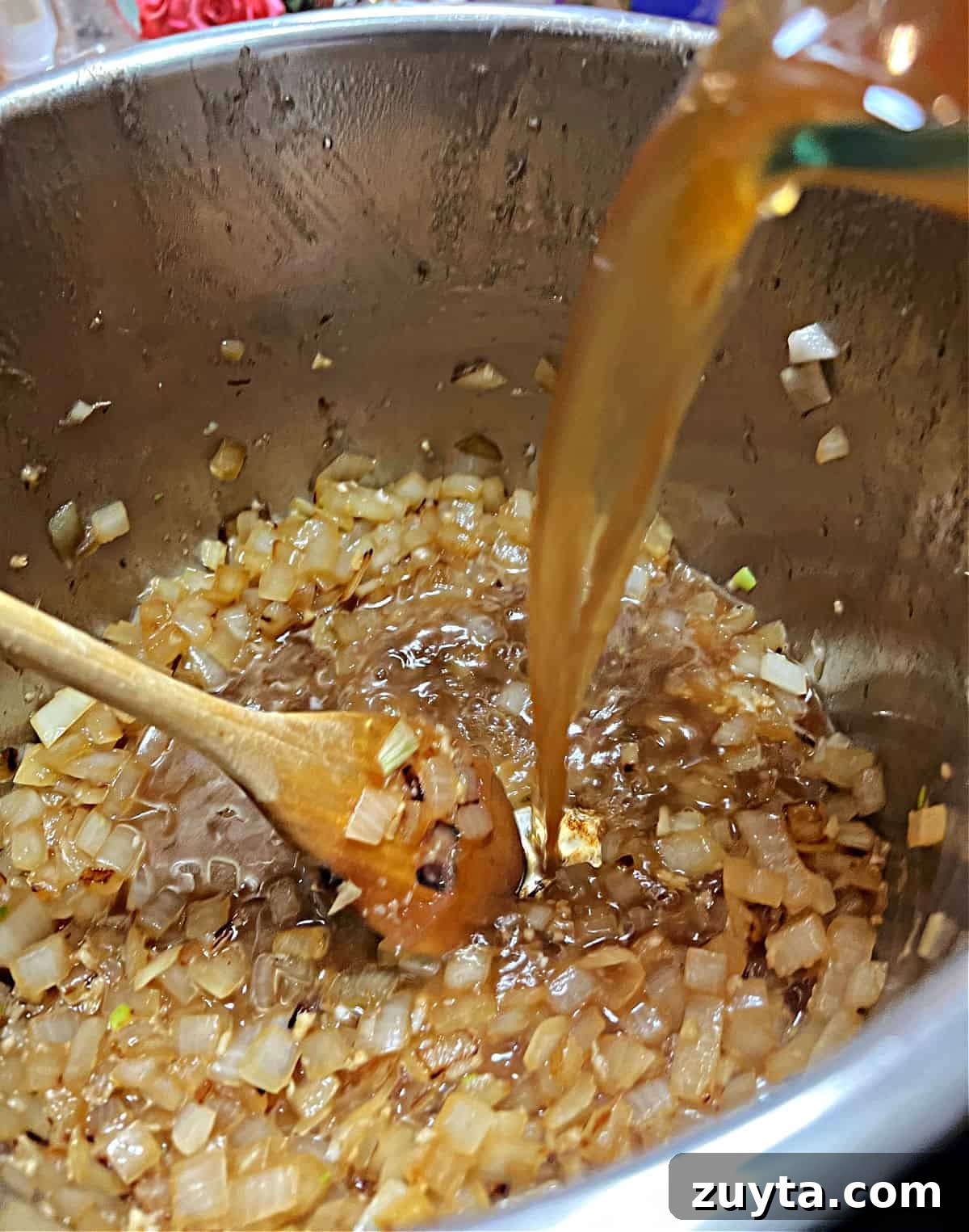 Adding broth to the pot.