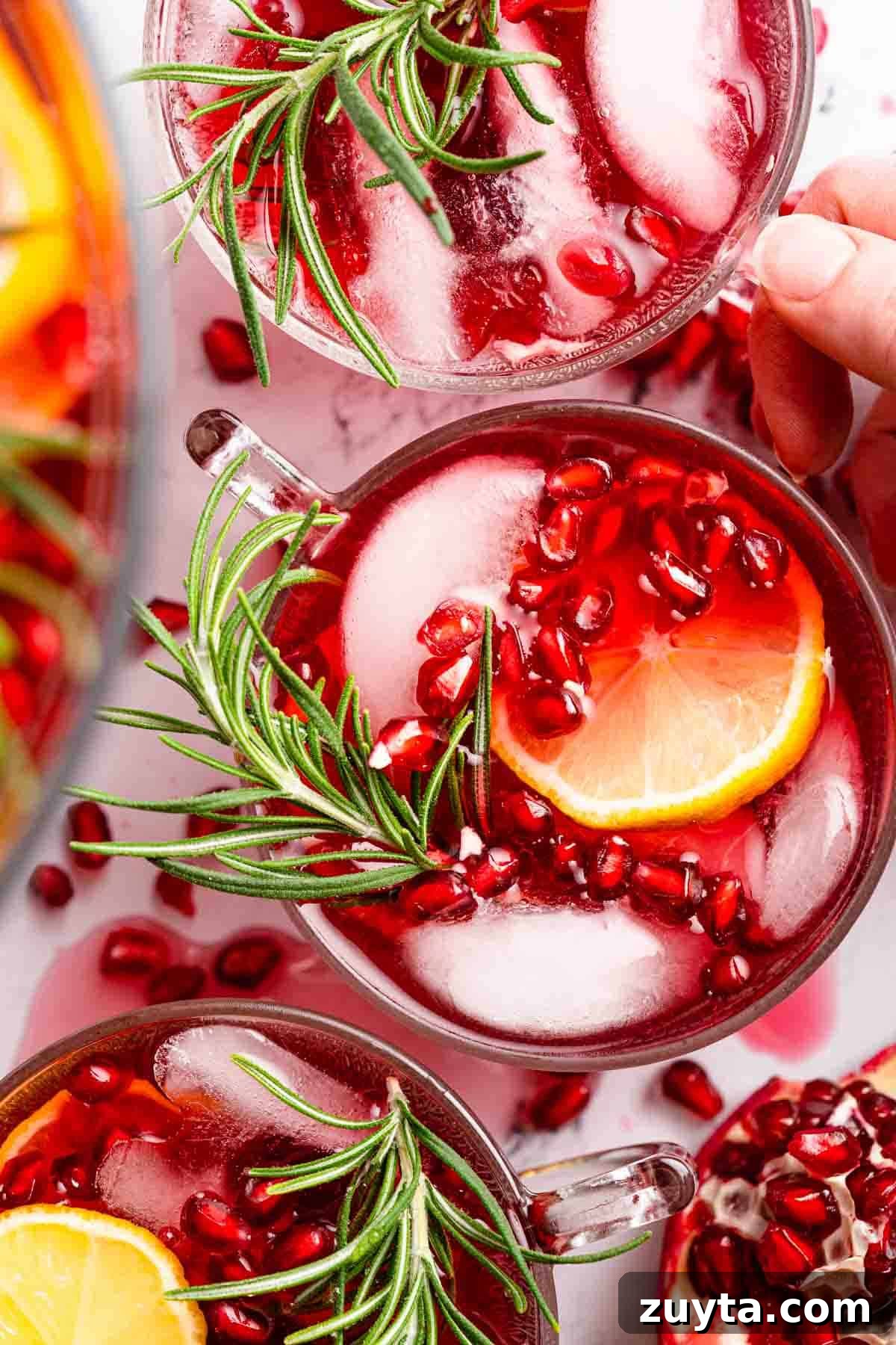 Sparkling Pomegranate Cranberry Punch Recipe 2 pomegranate punch in three punch cups garnished with lemon and pomegranate seeds