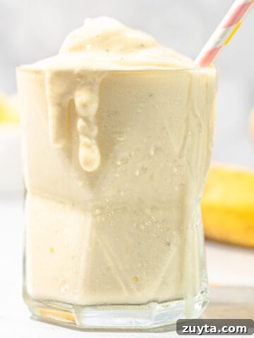 pineapple banana smoothie with bananas in background
