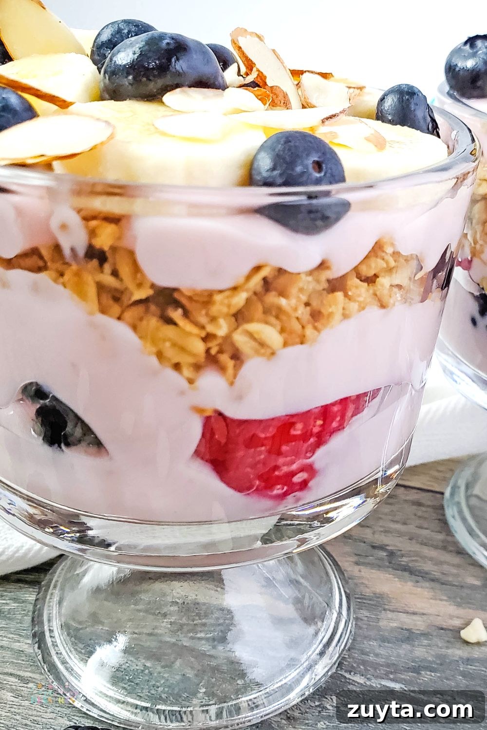 Close up image of mixed berry trifle with granola and banana