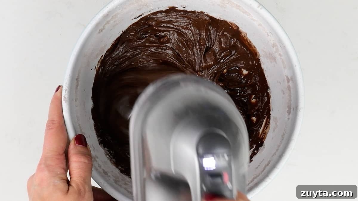 Decadent Chocolate Cake for Two Recipe 10 making chocolate frosting in a bowl with a hand mixer
