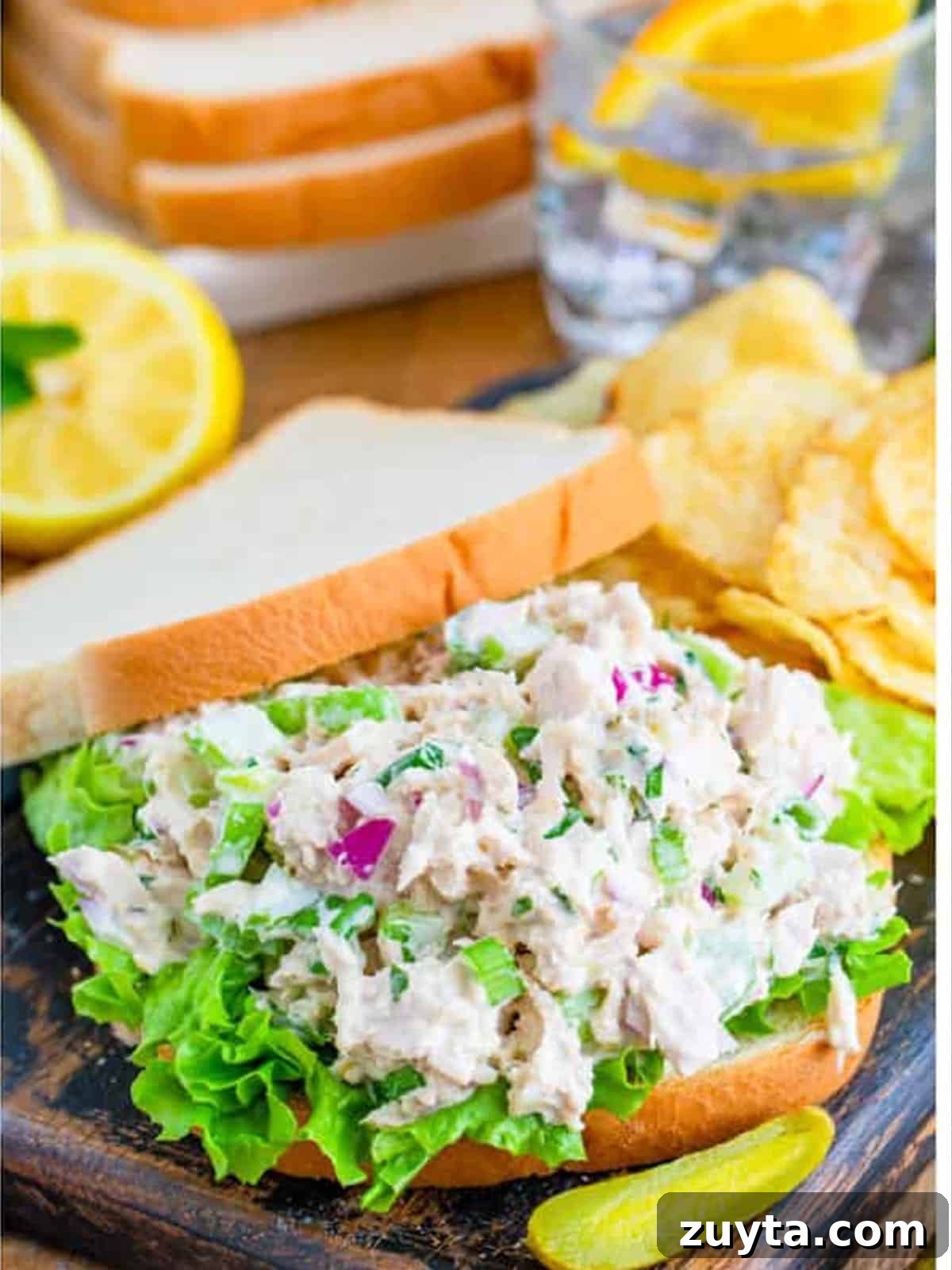 How to Make a Classic Tuna Salad Sandwich 4 Tuna salad piled on white bread with lettuce to build a tuna salad sandwich.