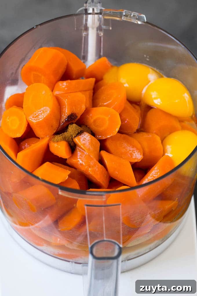 Cooked carrots, eggs, butter and spices in a food processor. Cooked carrots, eggs, butter and spices in a food processor.