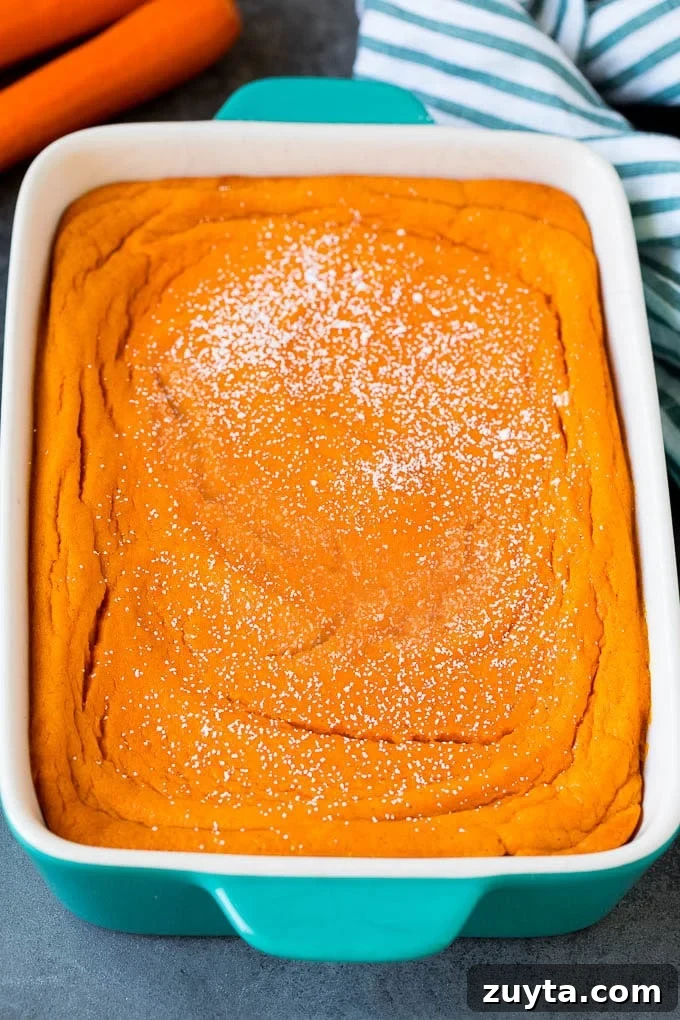 A baking dish of carrot souffle topped with powdered sugar. A baking dish of carrot souffle topped with powdered sugar.