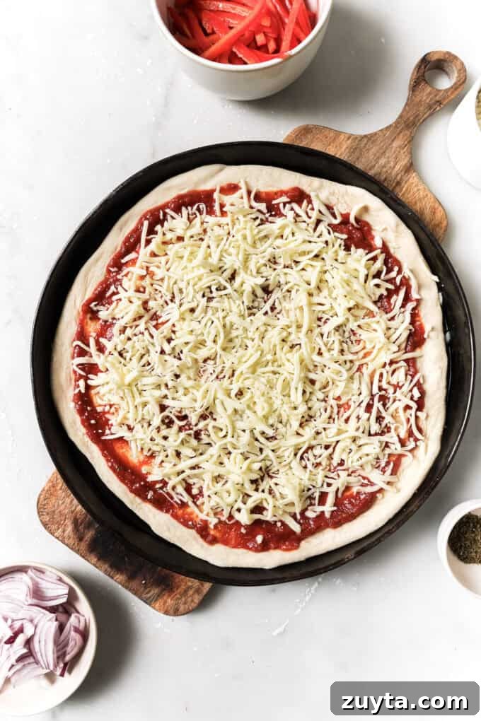 pizza dough topped with pizza sauce and shredded cheese