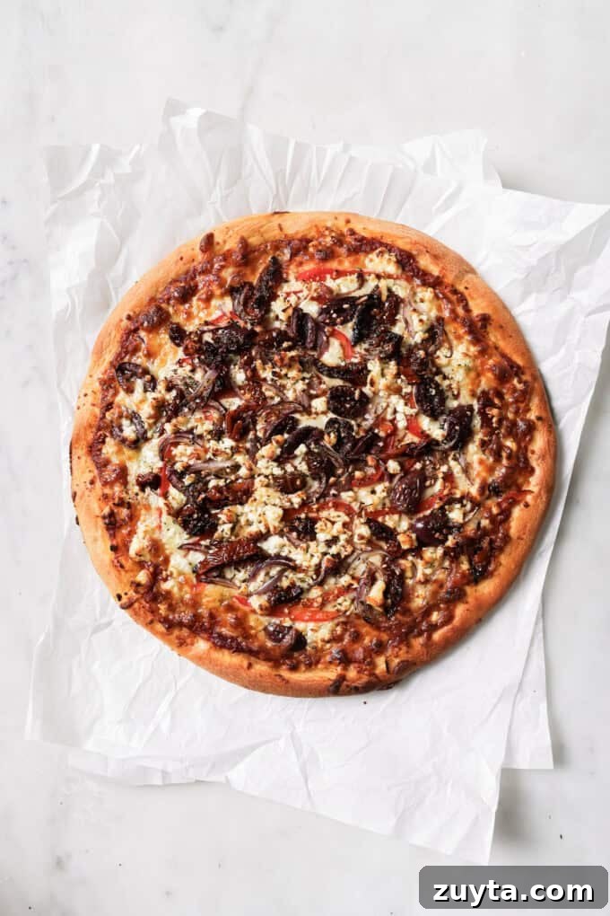 a cooked mediterranean pizza on parchment paper
