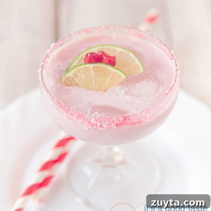 Fresh pomegranate cocktail with garnish of lime and pomegranate