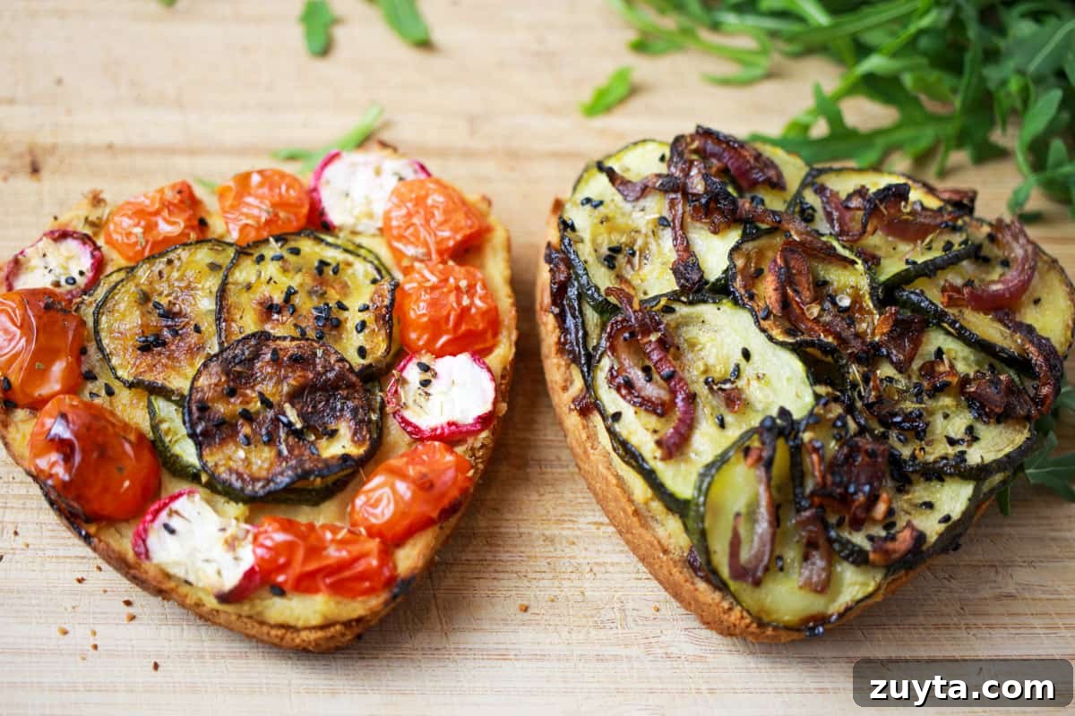 photo of two heart-shaped vegan Mediterranean roasted vegetable tarts on a wooden board.
