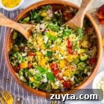 Colorful summer orzo salad with peaches, cherry tomatoes, cucumbers, and feta.