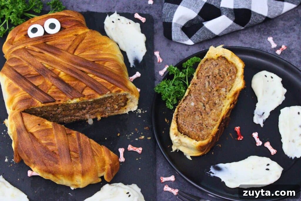air fryer mummy meatloaf cut open with a slice off to the side on a plate with ghost mashed potatoes