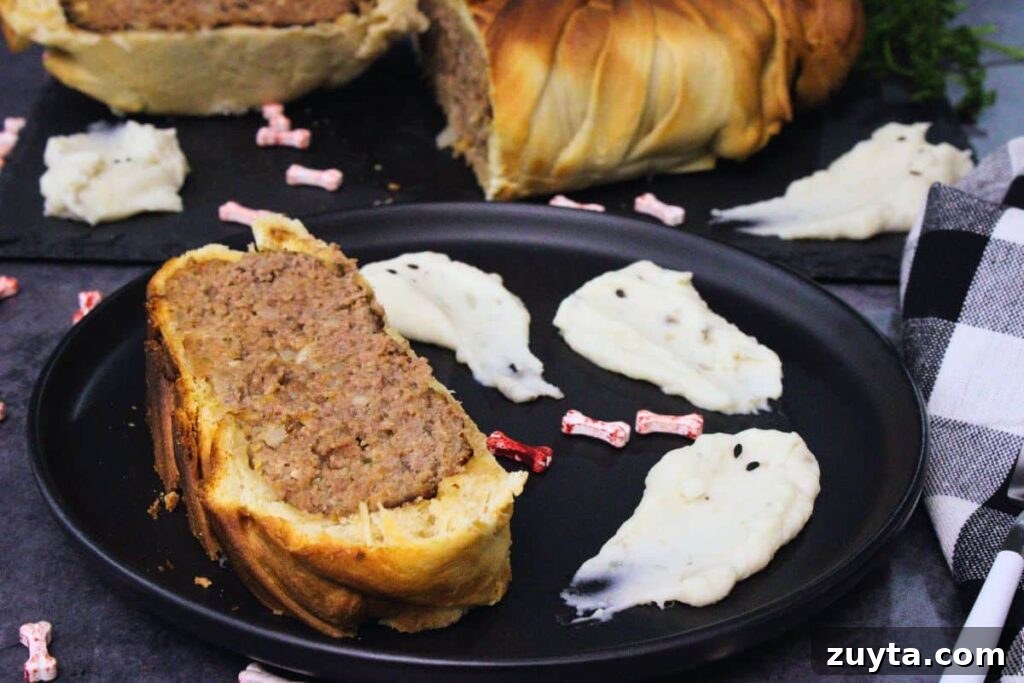 slice of mummy meatloaf on a plate next to spooky mashed potato ghosts