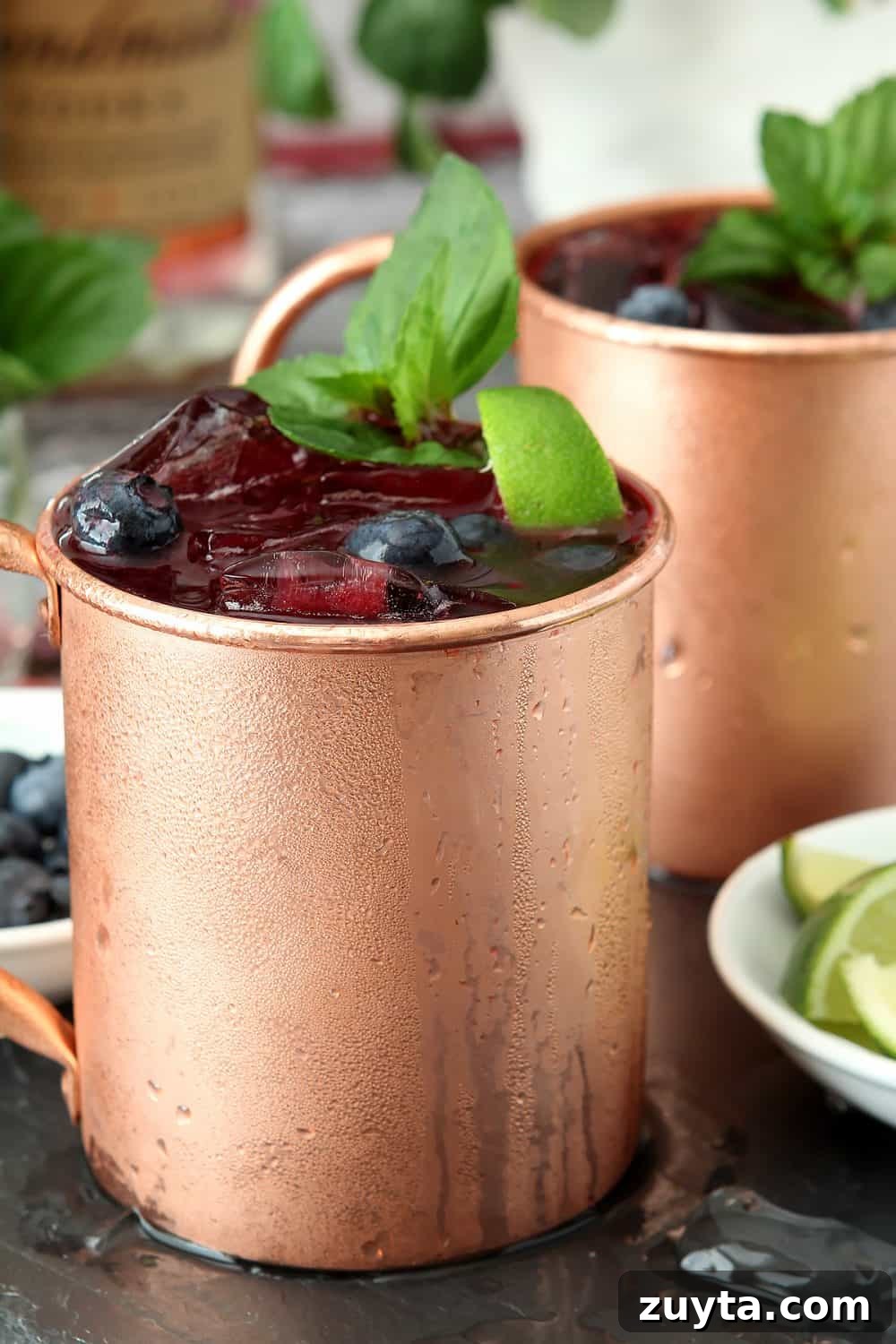 Blueberry Mint Moscow Mule Cocktail Recipe 4 Closeup of chilled copper mug with a Blueberry Mint Moscow Mule cocktail garnished with mint.