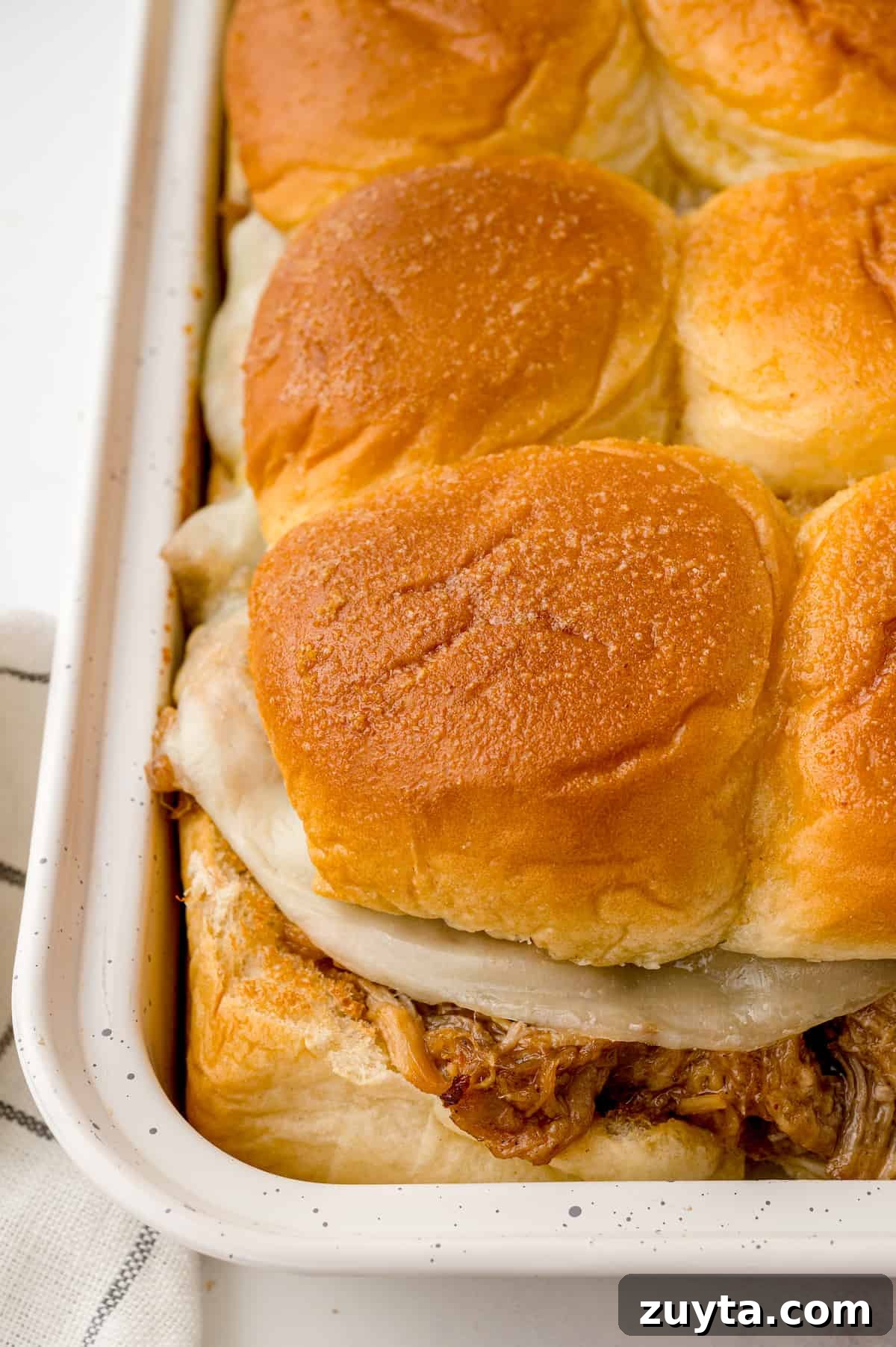 Pulled pork sliders with cheese in a pan.