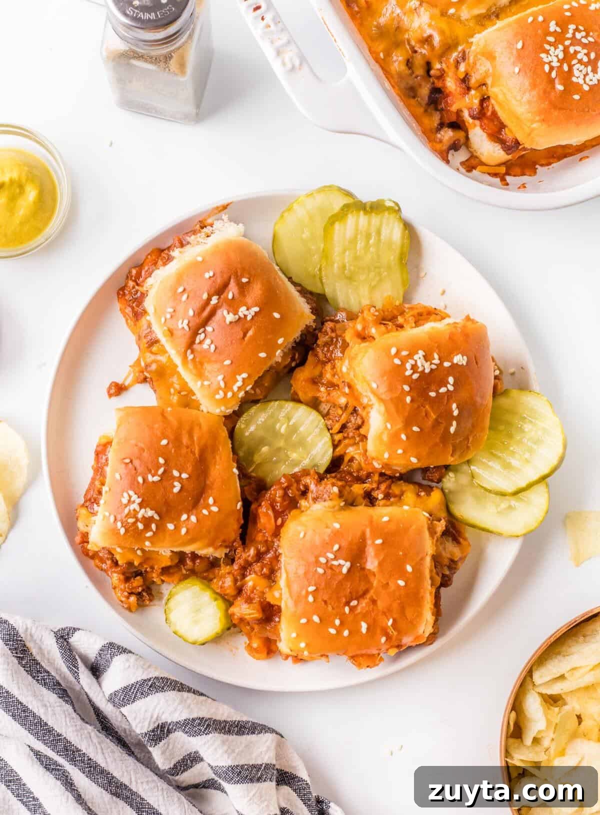 Sloppy Joe Sliders Recipe for Game Day and Parties 8 Plated sliders with potato chips and dill pickle chips.