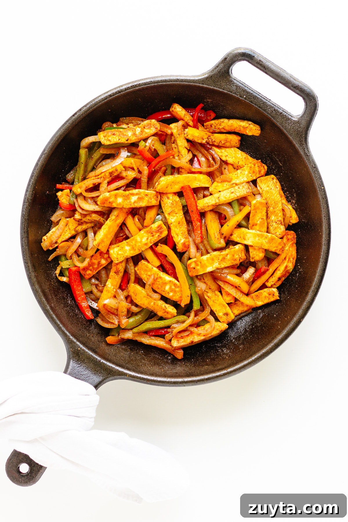 Grilled Halloumi Fajitas with Peppers and Lime 11 Fajita veggies with pan fried halloumi strips in a cast iron skillet.