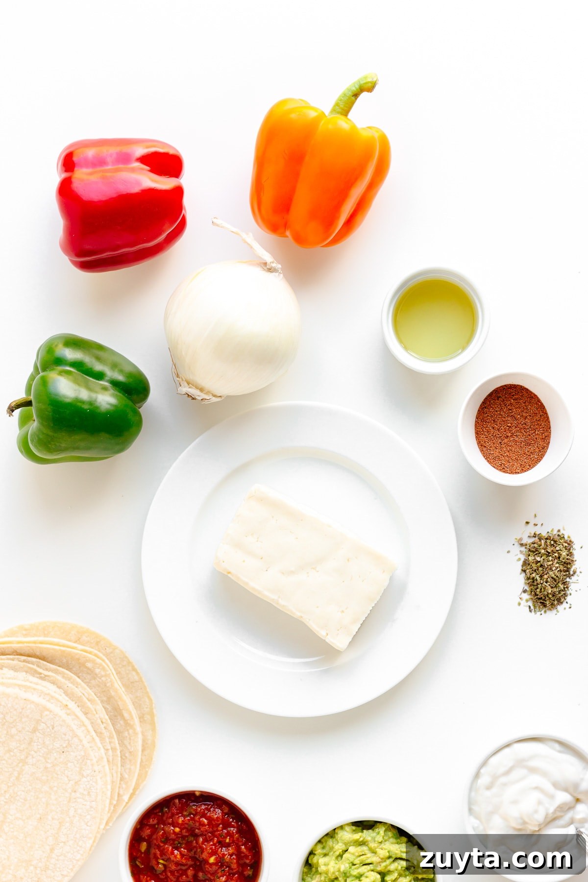 Grilled Halloumi Fajitas with Peppers and Lime 4 Flat lay of ingredients needed to make halloumi fajitas on a white background.