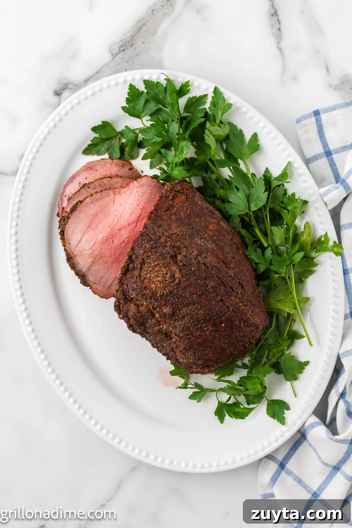Smoked eye of round on a platter with fresh herbs