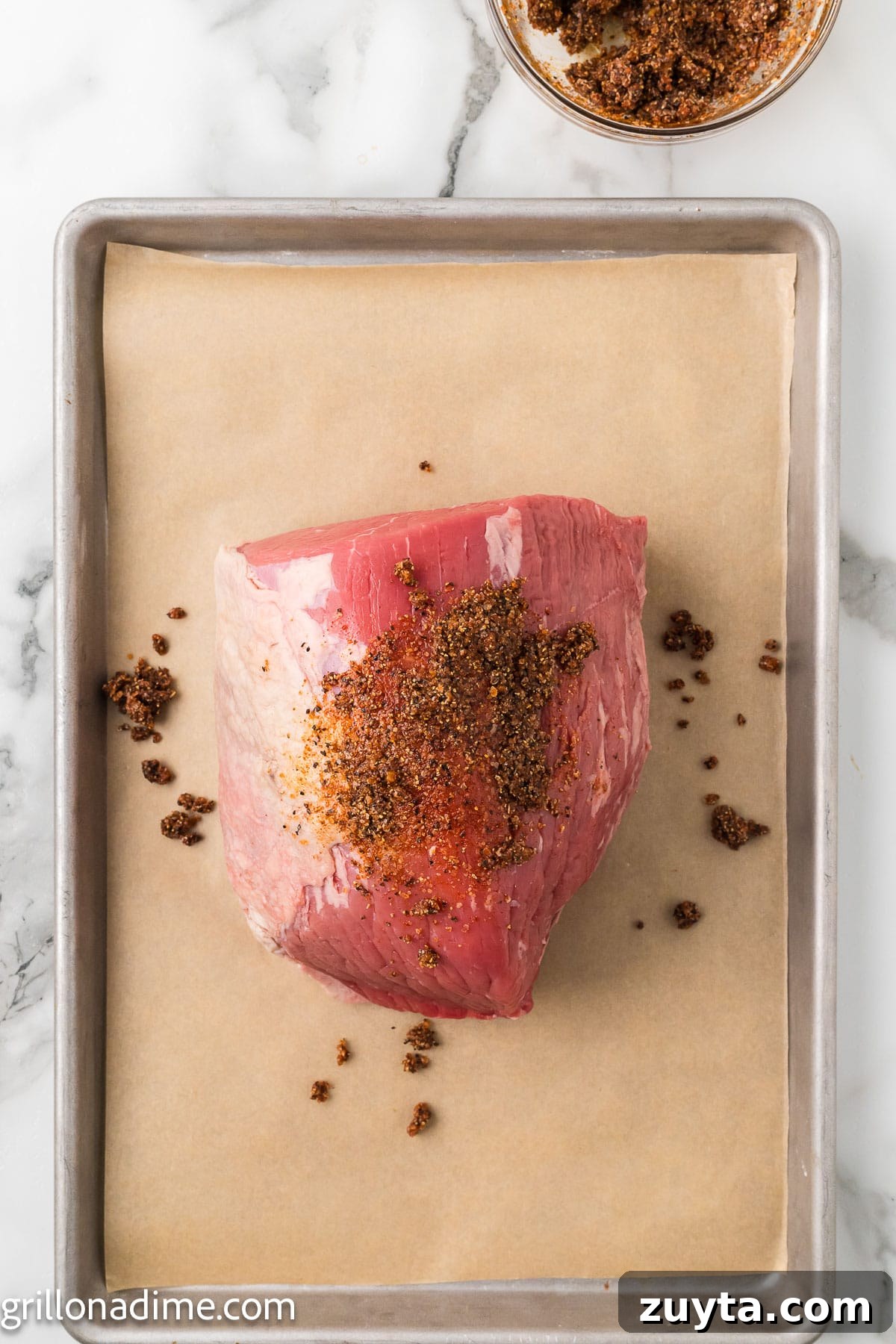 Rubbing the sauce over the roast on a baking sheet