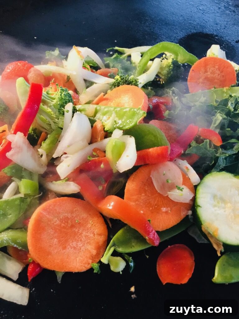 Blackstone Griddle Peanut Chicken Stir Fry Recipe 7 adding the vegetables for Blackstone Peanut Chicken Stir Fry