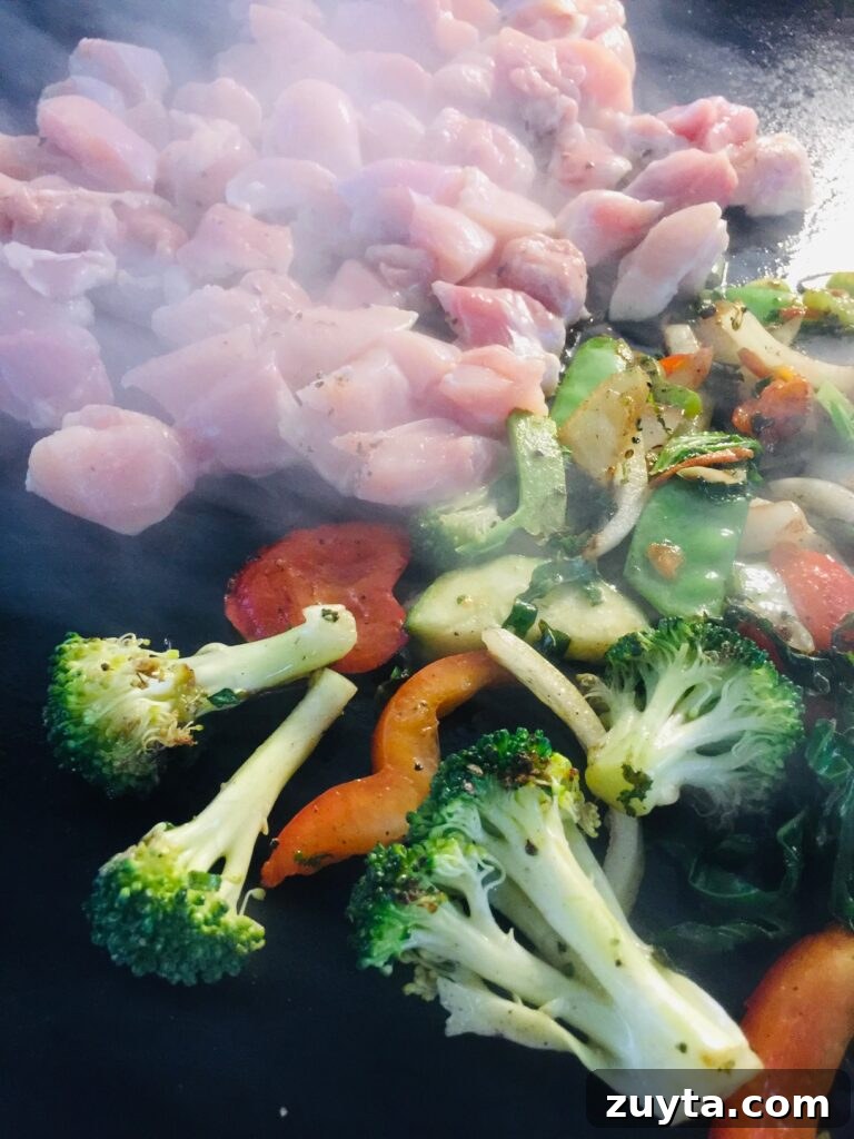 Blackstone Griddle Peanut Chicken Stir Fry Recipe 8 adding chicken to the griddle