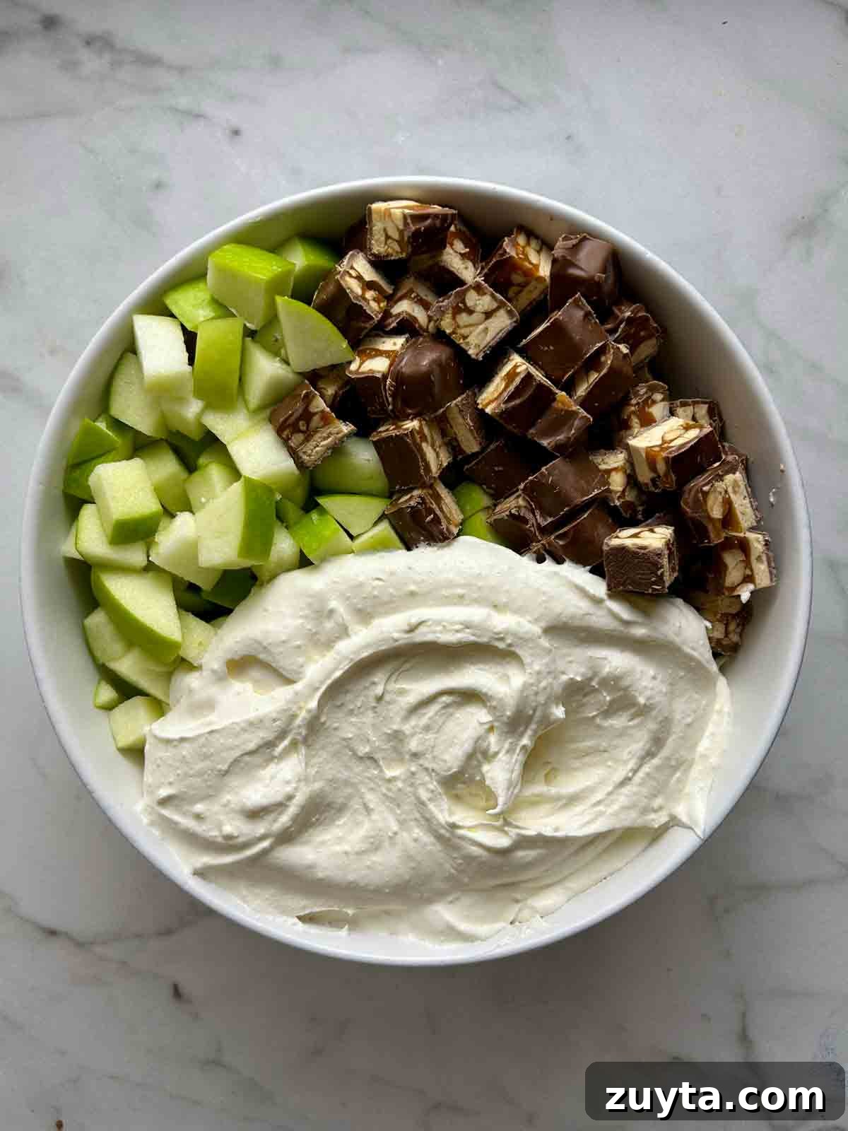 Snickers Salad Recipe: Creamy No-Bake Dessert with Apples 7 all components in bowl; unmixed.