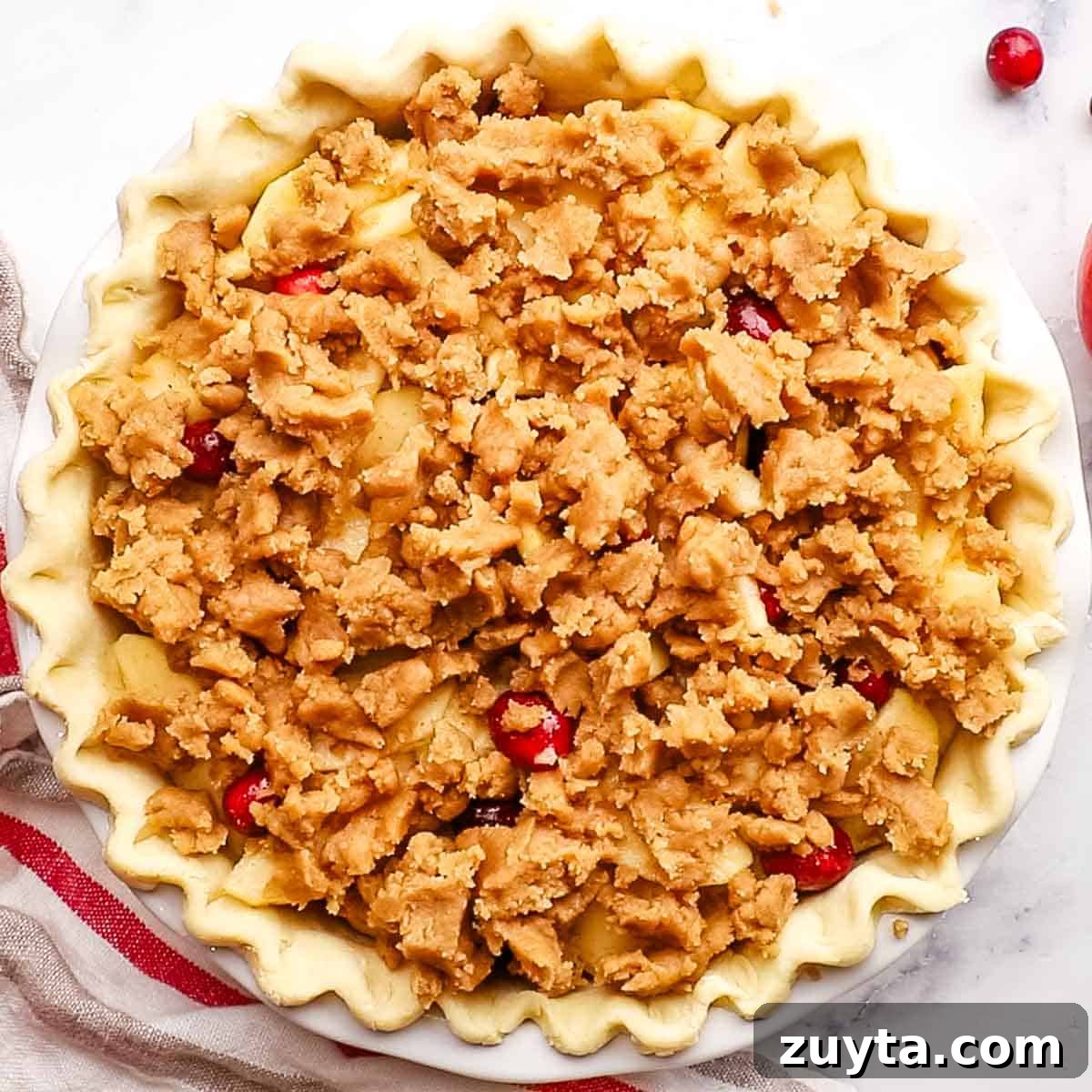 Rustic Apple Cranberry Crumble Pie Recipe 9 overhead view of unbaked apple cranberry pie with a crumble topping