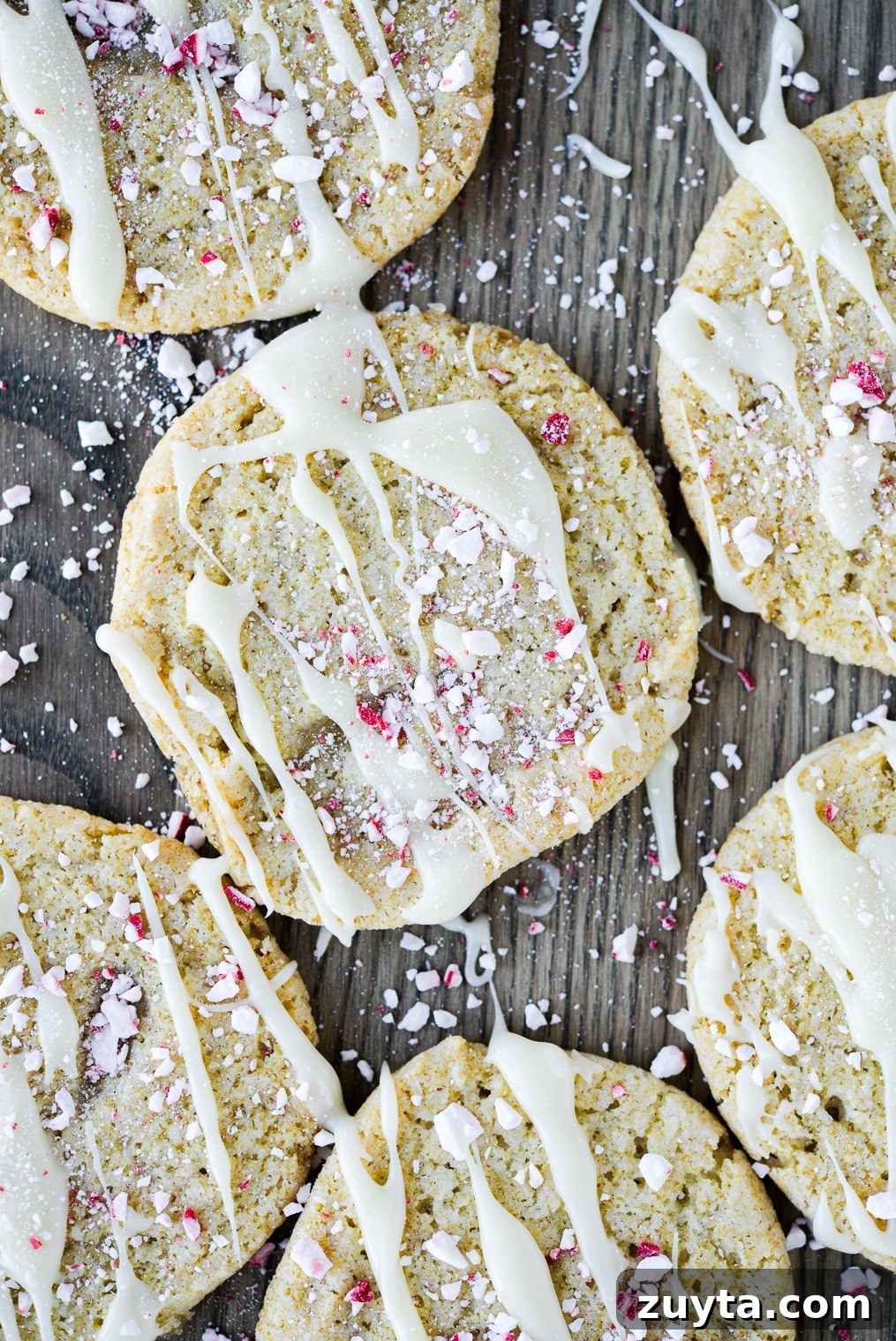 White Chocolate Peppermint Icebox Cookies Recipe 11 sugar cookies drizzled with white chocolate and crushed peppermints on a wooden surface