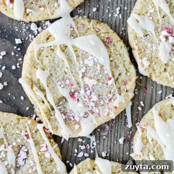 White Chocolate Peppermint Icebox Cookies Recipe 16 sugar cookies drizzled with white chocolate and crushed peppermints on a wooden surface