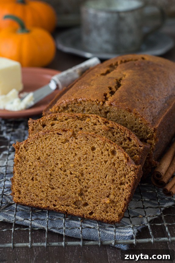 Copycat Starbucks Pumpkin Bread Recipe 3 pumpkin bread loaf sliced into 2 pieces on metal cooling rack