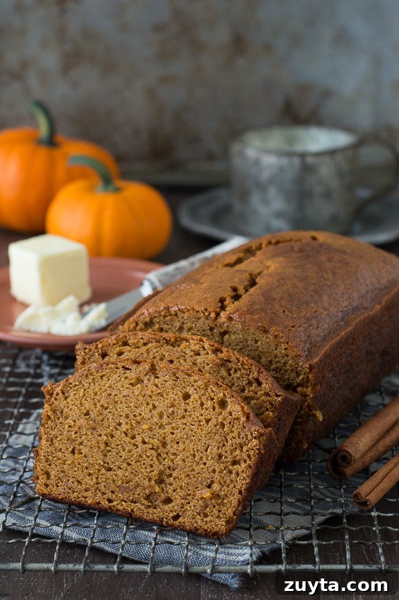 Copycat Starbucks Pumpkin Bread Recipe 7 pumpkin bread loaf sliced into 2 pieces on metal cooling rack