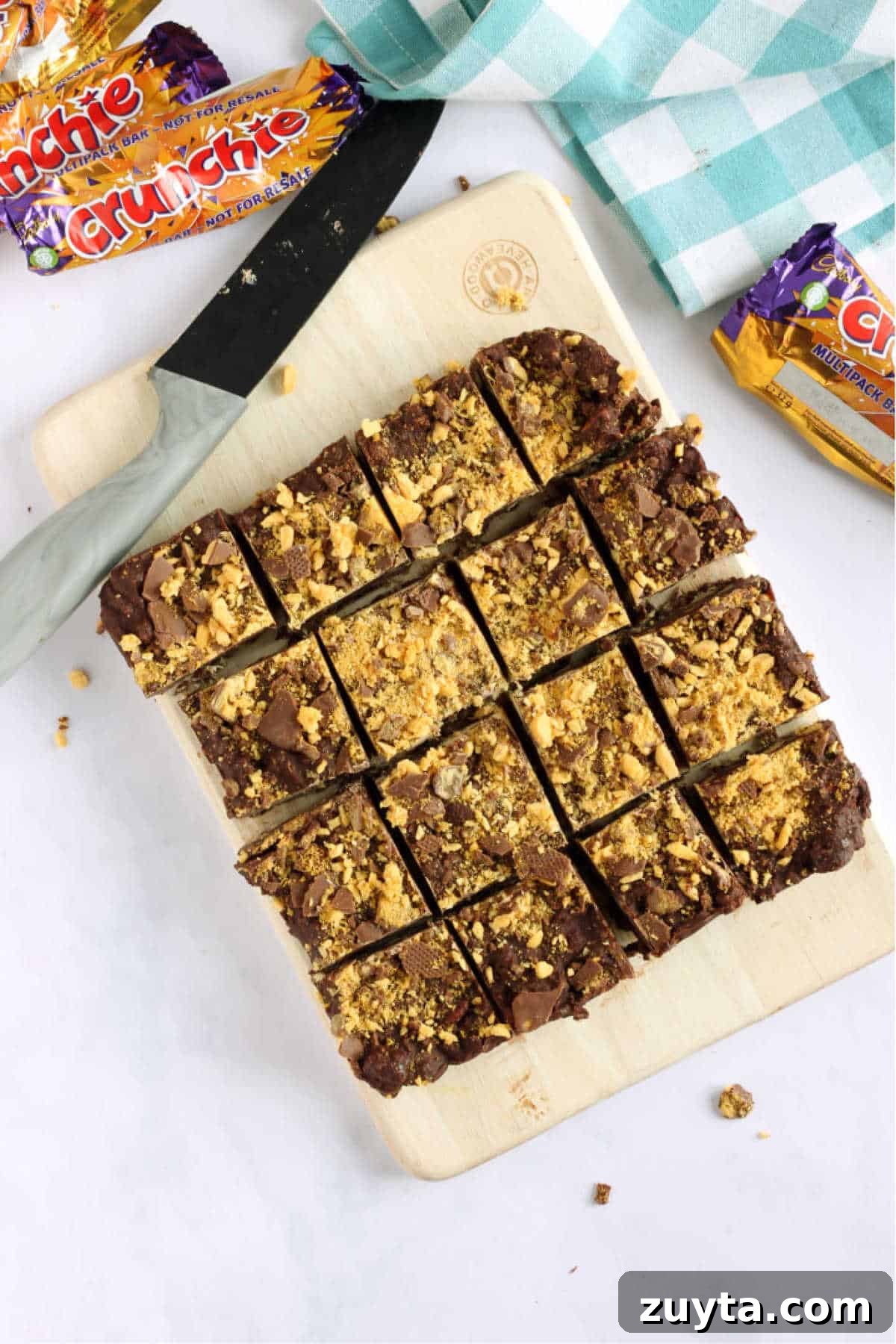 No-Bake Honeycomb Crunchie Tiffin Recipe 3 Overhead shot of chocolate crunchie tiffin, cut into squares with a grey knife.