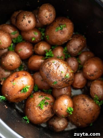 Crock pot filled with potatoes cooking.