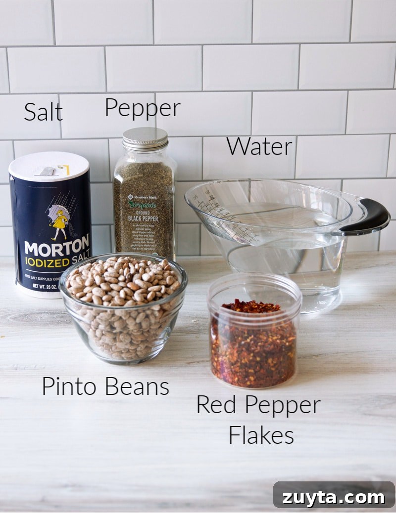 Slow Cooker Pinto Beans Recipe 5 Beans, salt, pepper, water, and crushed red pepper on a counter.