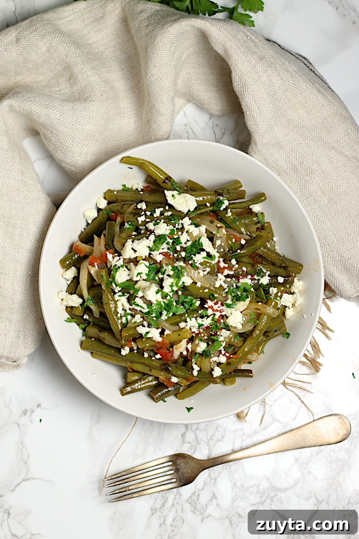An overhead photo of Greek-Style Green Beans in a white bowl.