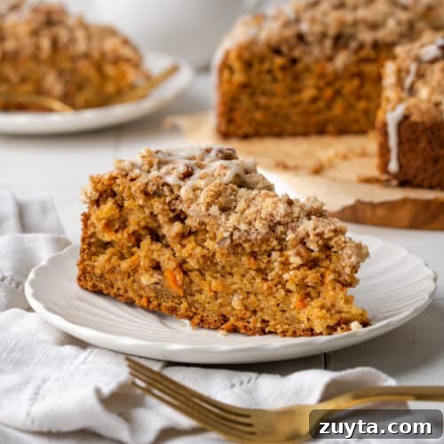 A slice of carrot coffee cake on a white plate.