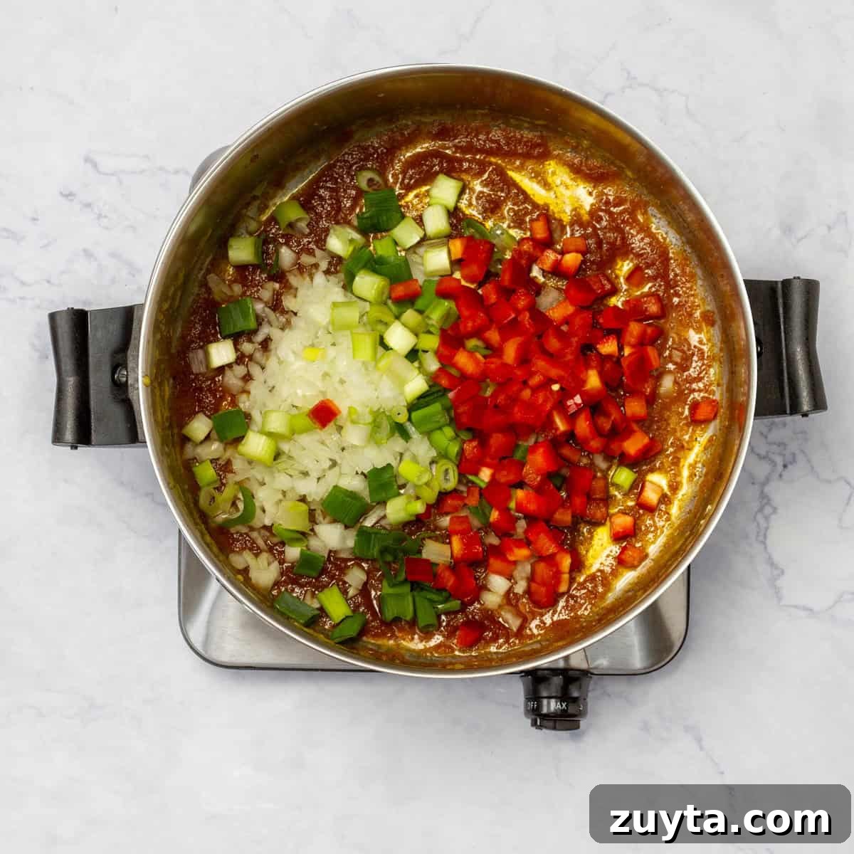 add the chopped onion, green onions, and red bell pepper to the Roux