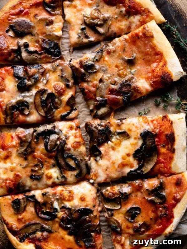 An overhead shot of a Taleggio and Mushroom Pizza cut into 8 slices.